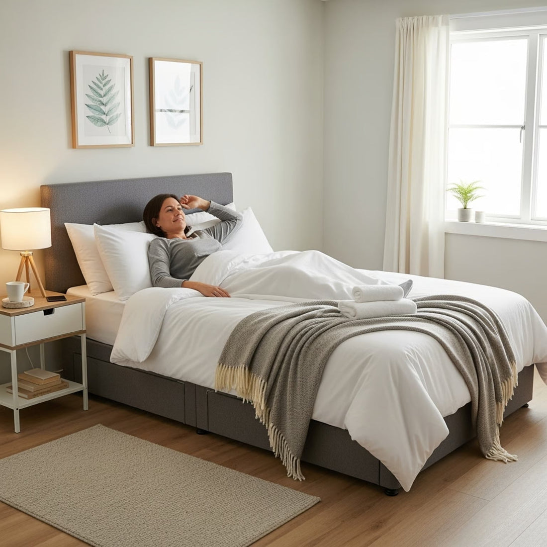 a small double divan bed with an adult in it