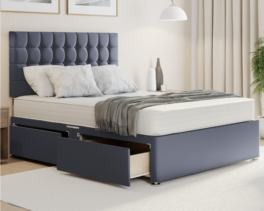 grey plush cubex style divan bed with mattress and storage drawers.